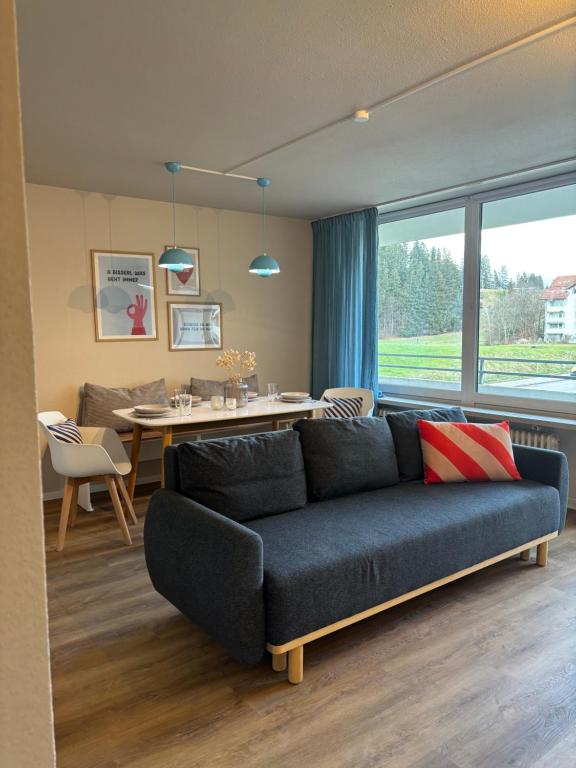 Una sala de estar con un sofá azul y una mesa. en Apartment W35, en Füssen