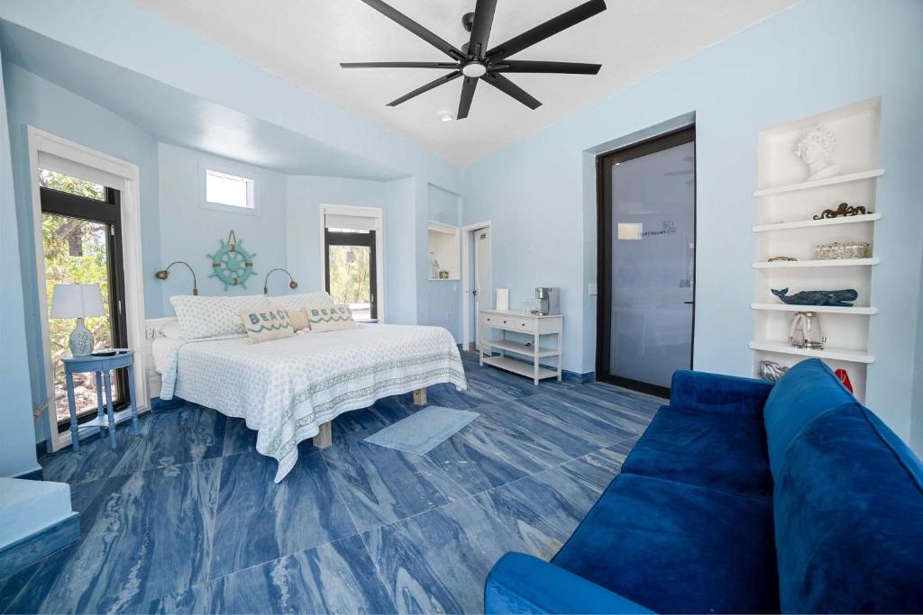 a bedroom with a bed and a blue couch at Ocean Depth Room at Barnacle Resort in Big Pine Key