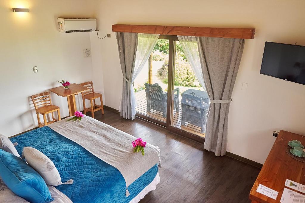 a bedroom with a bed and a sliding glass door at Takarua Lodge in Hanga Roa