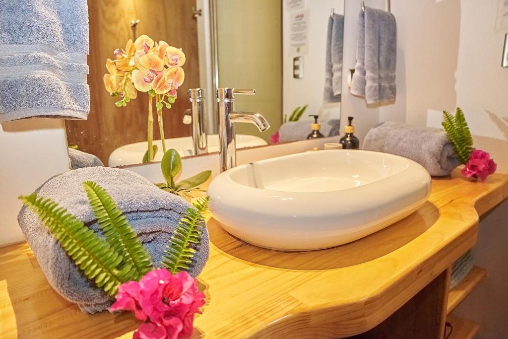 a bathroom with a white bowl sink on a wooden counter at Takarua Lodge in Hanga Roa
