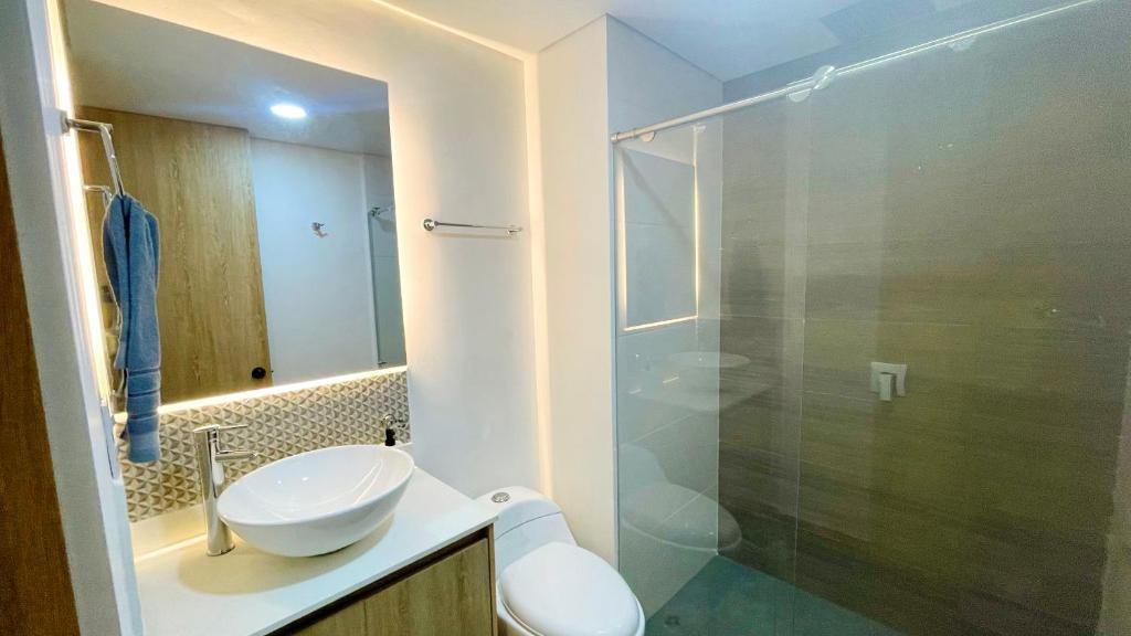 a bathroom with a sink and a glass shower at Loft Industrial ubicación ideal in Armenia