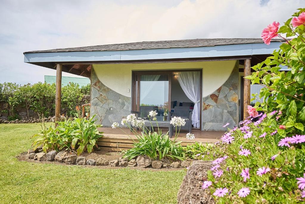 a stone house with a porch with a window at Takarua Lodge in Hanga Roa