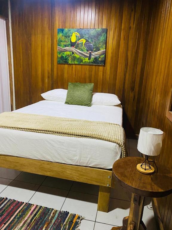 a bedroom with a bed and a table with a lamp at Casa 1856- cómodas habitaciones en el Centro de Alajuela in Alajuela City