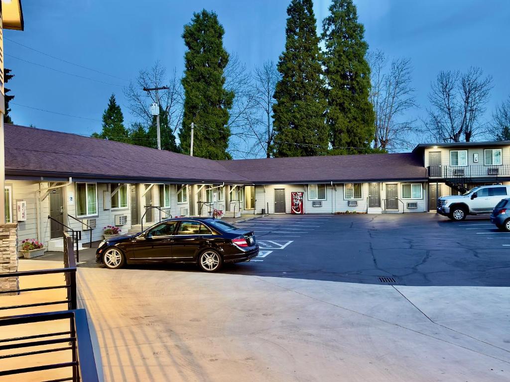 a car parked in a parking lot in front of a building at Budget Lodge Eugene - Airport in Eugene