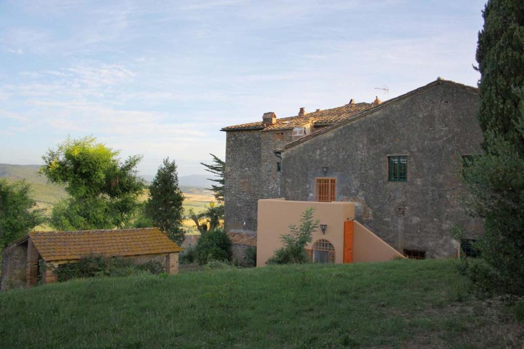 stary kamienny dom na trawiastym wzgórzu w obiekcie Fattoria della Gioiosa - Agriturismo La Gelinda w mieście Casale Marittimo