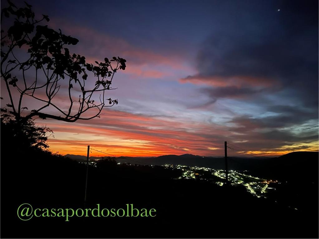 a sunset with a view of a city at Casa Pôr do Sol in Baependi