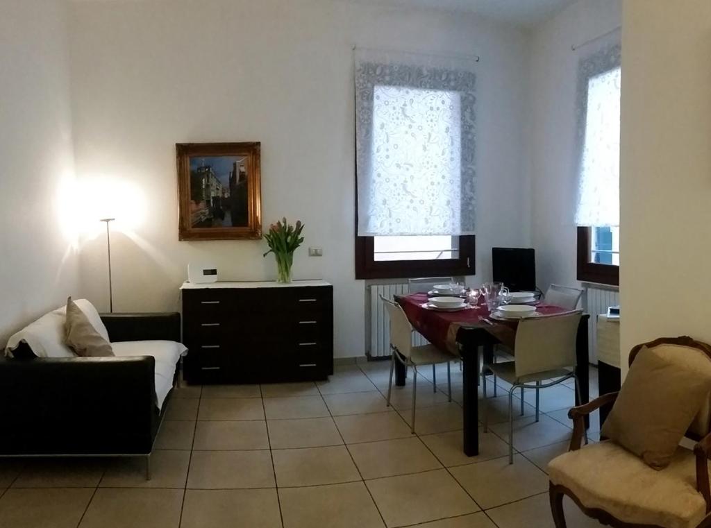 a living room with a table and a dining room at Santa Croce Apartment in Venice