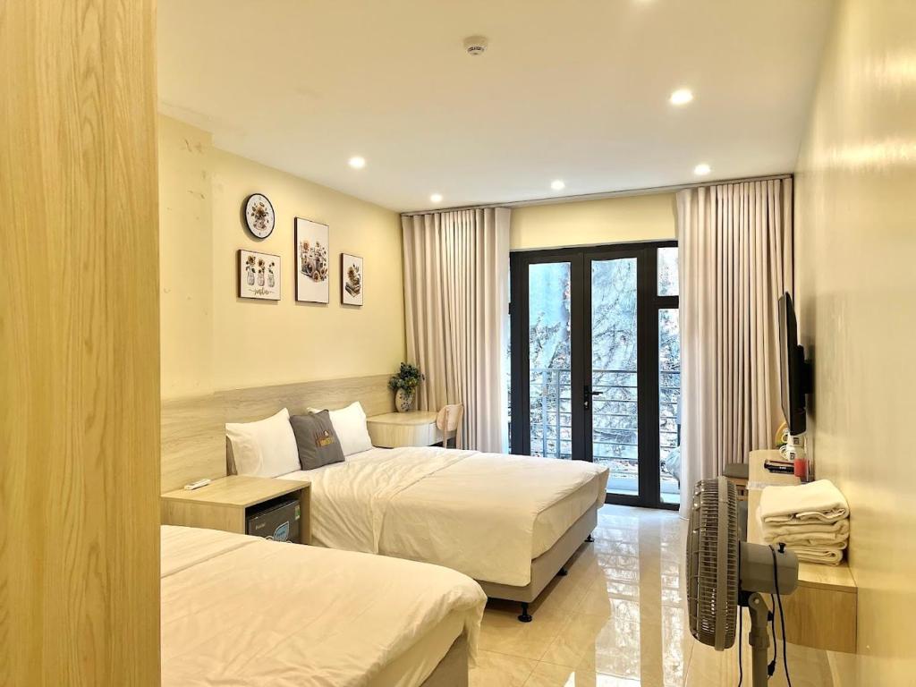 a hotel room with two beds and a television at Hanoi’s Lane Homestay in Hanoi