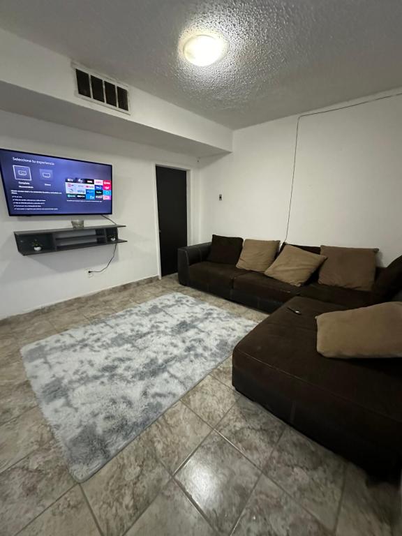 a living room with a couch and a flat screen tv at Departamento independiente en Juárez in Ciudad Juárez