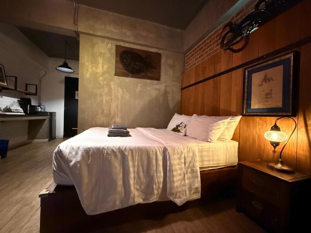 A close bedroom view centered on a white-covered bed and dark wood headboard.