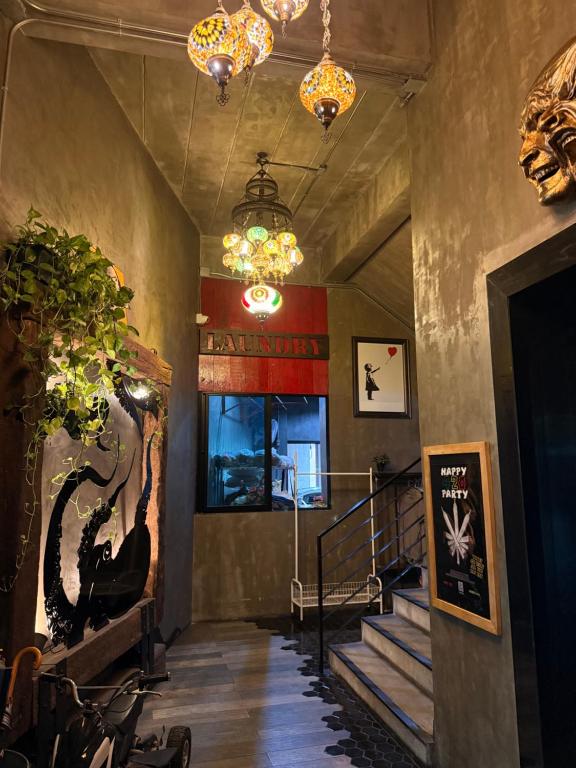 An atmospheric interior stair hall with decorative chandeliers, plants and bold artwork.