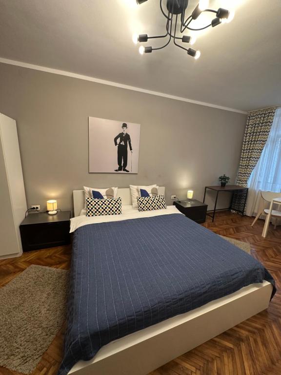 een slaapkamer met een groot bed met een blauwe deken bij Casa Corona in Braşov