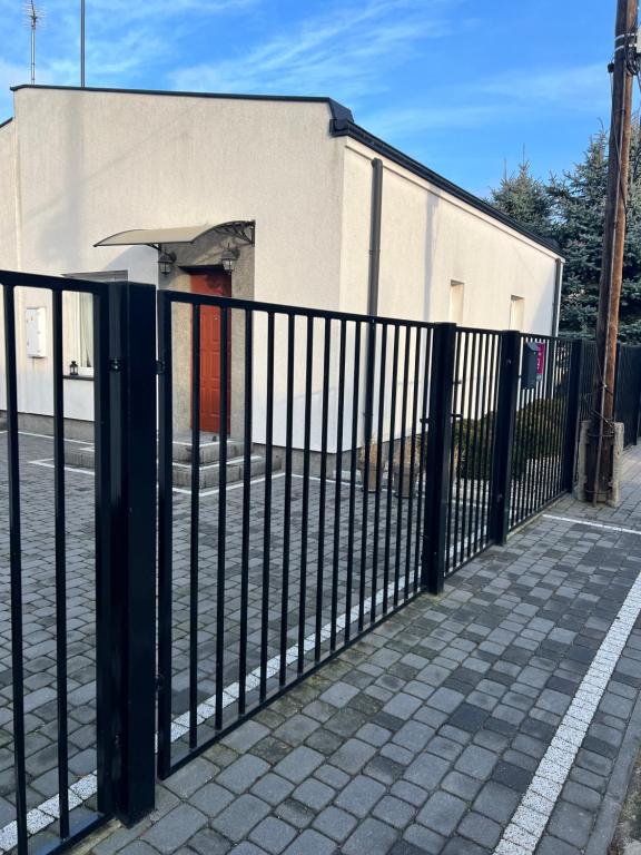 a black fence in front of a building at Różana City Apartaments in Kutno