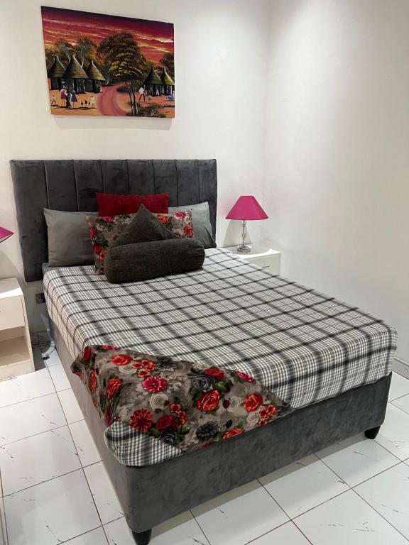 Manshu Guest House في هراري: غرفة نوم مع سرير وبطانية مقلية