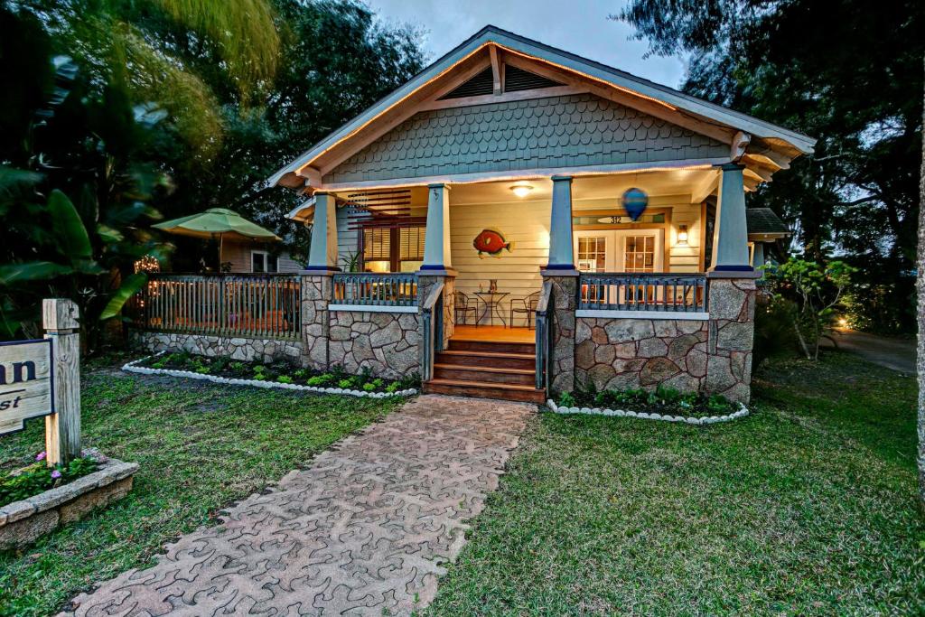 a small house with a porch and a fence at Anchor Inn NSB Bed and Breakfast in New Smyrna Beach