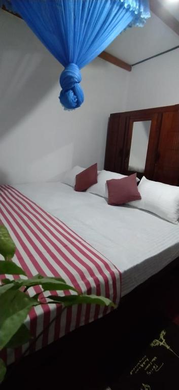 a bedroom with a bed with a blue ceiling at Lotus Paradise in Weligama