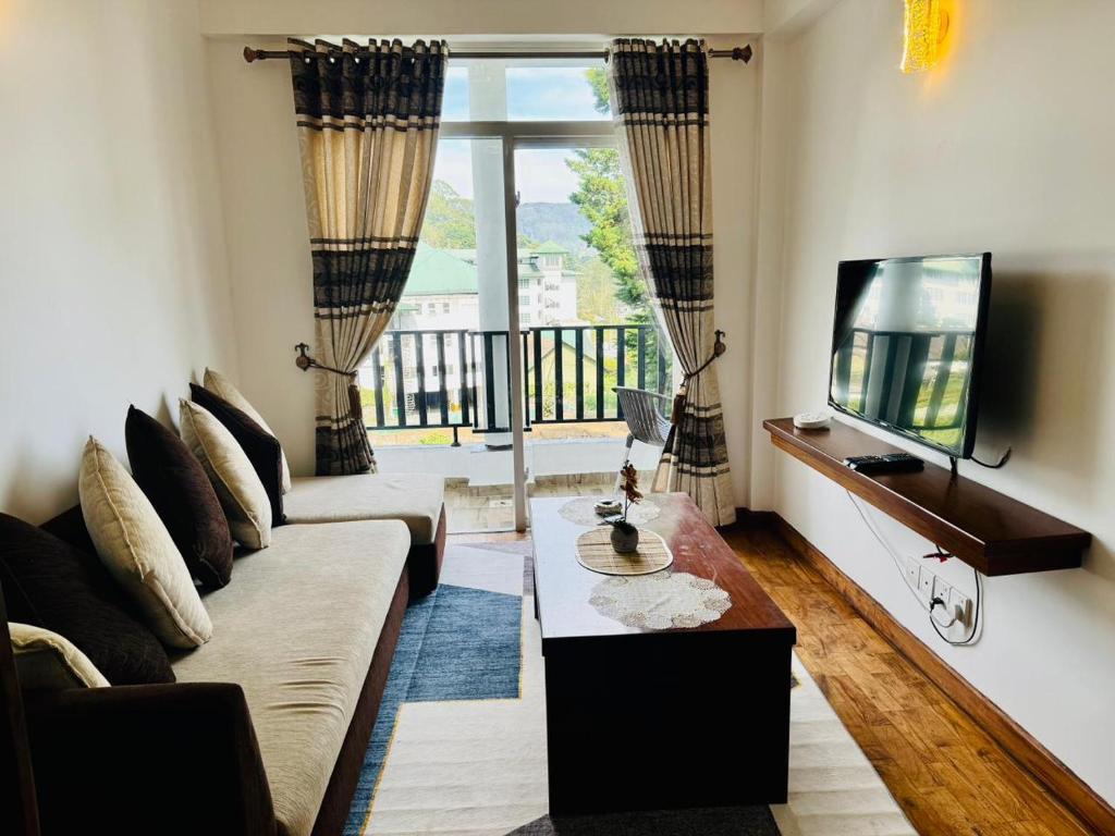 a living room with a couch and a tv at Highland View in Nuwara Eliya