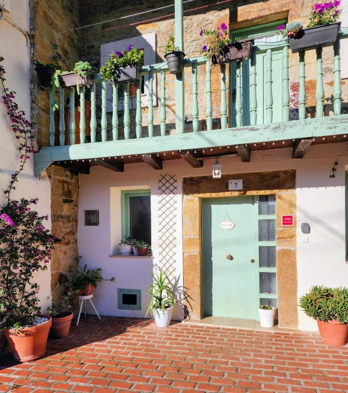 a building with a green door and a balcony at La Esmeralda in Hornedo