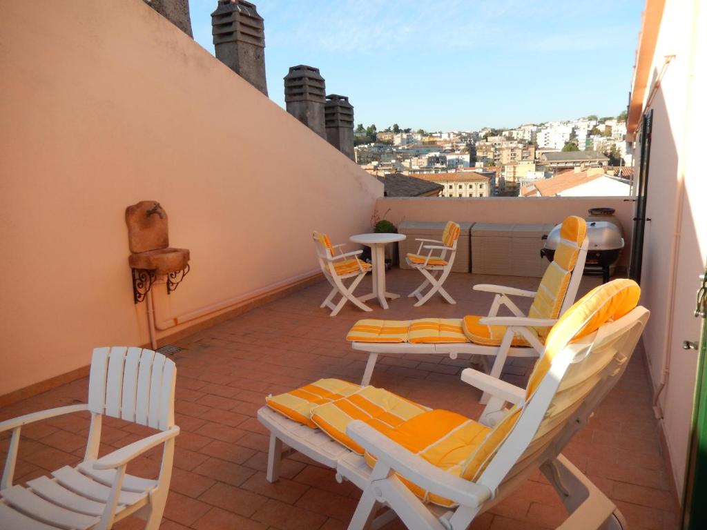 uma varanda com cadeiras e mesas e vista para a cidade em La Terrazza Apartment em Ancona
