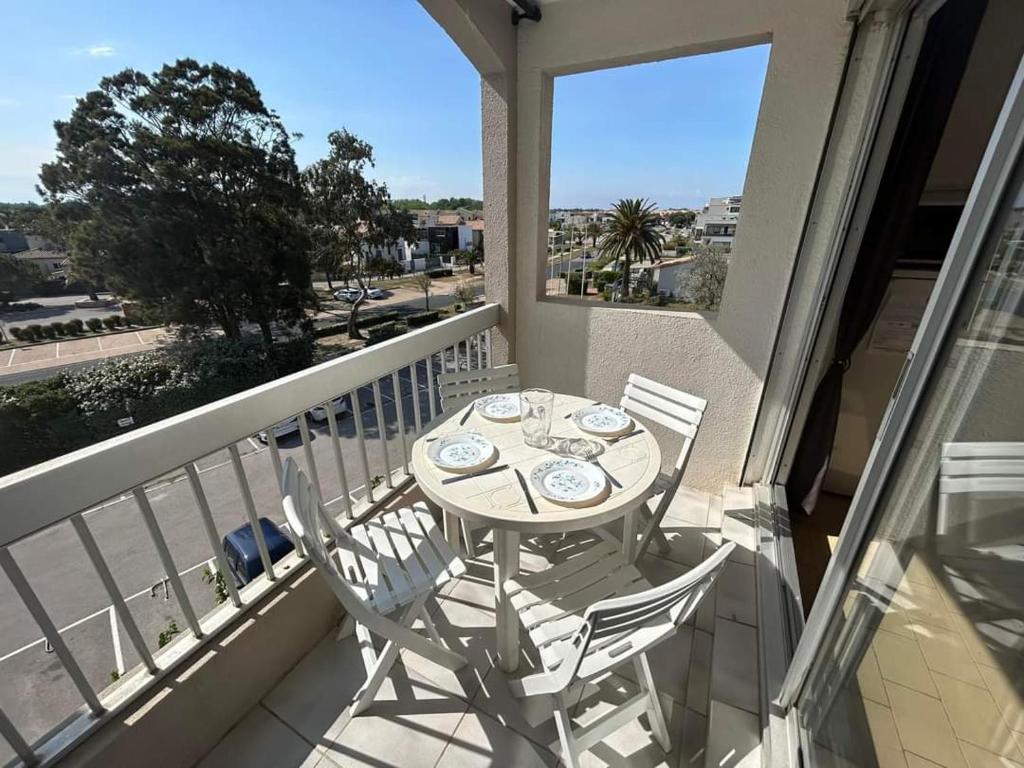 une table et des chaises sur un balcon avec vue dans l'établissement Les Fregates - Appart 4 pers proche plage et piscine, à Saint-Cyprien