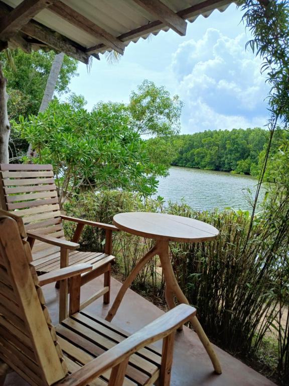 un tavolo e sedie su una veranda con vista sul fiume di Ginger Harmony Guesthouse and Cafe a Tangalle