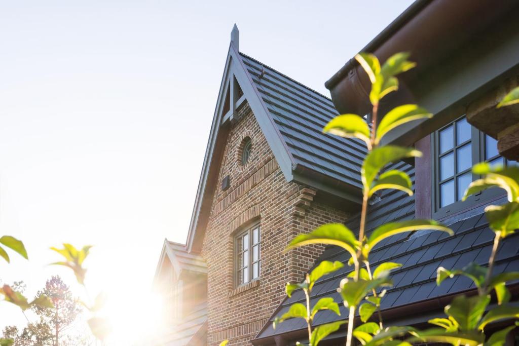 une maison avec un toit noir et une usine dans l'établissement Sky & Sand, à Westerland