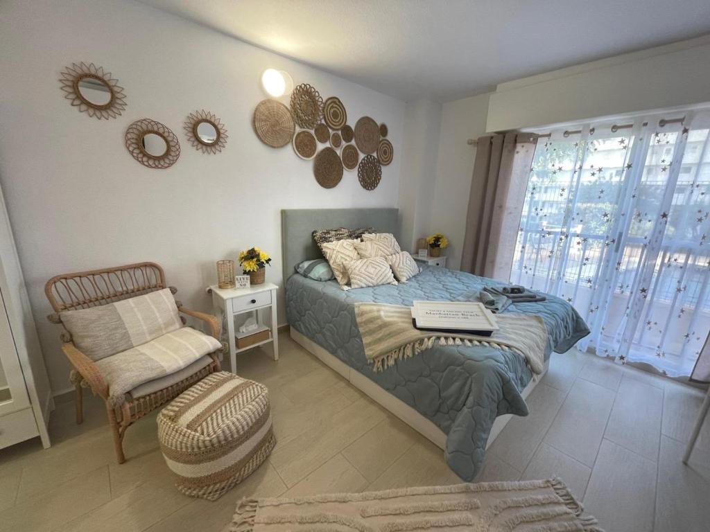 a bedroom with a bed and a chair and mirrors at Reel Apartments- Luxury Studio with swimming pool. in Torrevieja