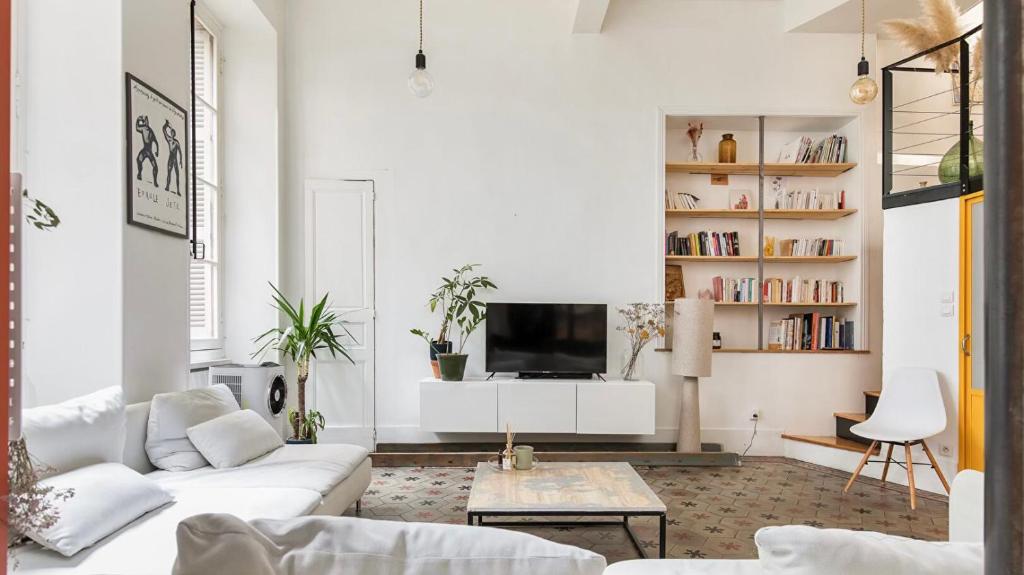 Il comprend un salon doté d'un mobilier blanc et d'une télévision. dans l'établissement Le Yellow Submarine - Loft - Hyper centre, à Toulouse