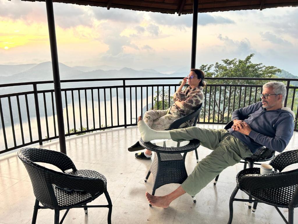 two people sitting in chairs on a balcony at Heritage Farm Kerala in Idukki