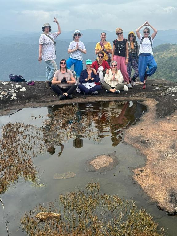 a group of people sitting on top of a mountain at Heritage Farm Kerala in Idukki