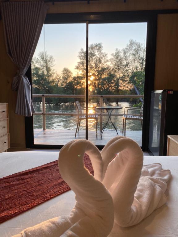 a sculpture of a heart on a bed in front of a window at rimbaymangrove resort in Ban Khlong Tamru