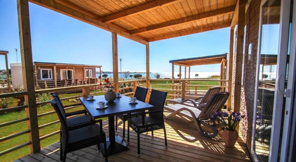 a wooden deck with a table and chairs on it at Holiday Mobile Homes Park Riviera in Novigrad Istria