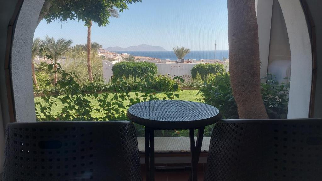 ein Tisch und Stühle auf einem Balkon mit Blick auf das Meer in der Unterkunft Blocco 59 Domina Coral Bay in Sharm El Sheikh