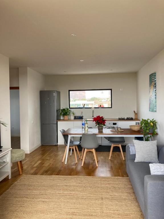 Una cocina y una sala de estar con una mesa y un sofá. en Villa Eka 2, en La Oliva