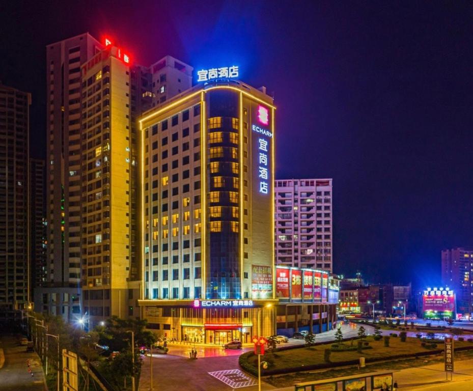 玉林Yishang Hotel Yulin Rongxian Rongzhou Commercial Plaza Branch的夜晚城市里灯火通明的建筑