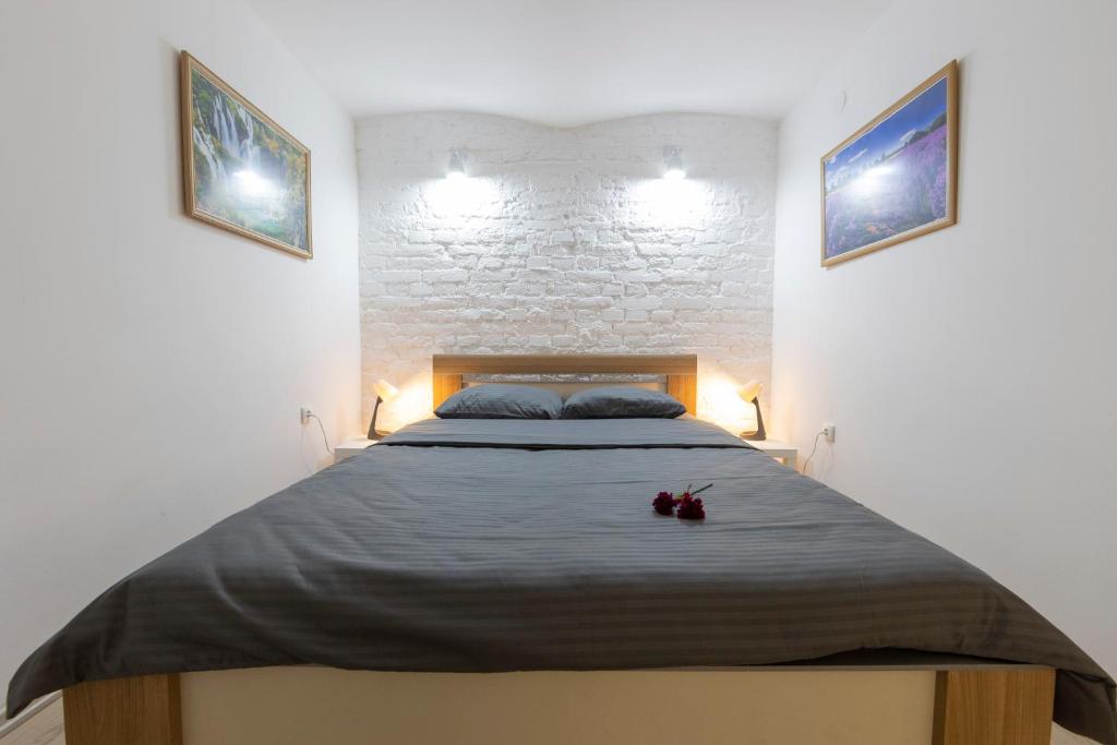 Una cama en un dormitorio con dos cuadros en la pared. en 011 Milesevska, en Belgrado