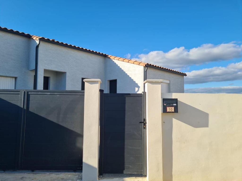 PezensにあるCharmante villa à Pezensの家の前の黒門