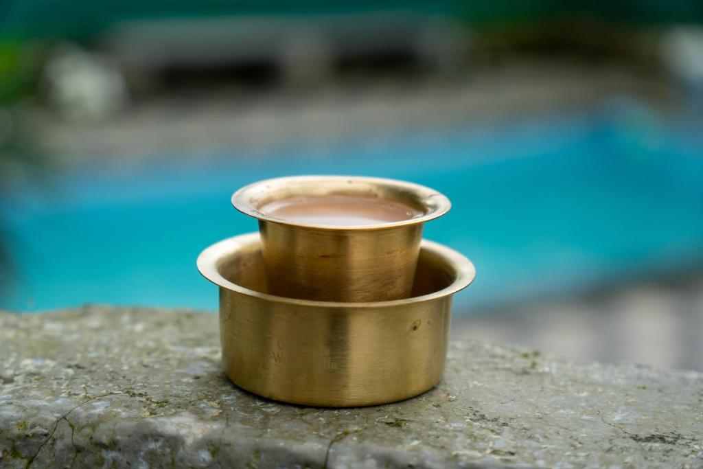 a gold cup of coffee sitting on a rock at Club Woods Villa - Gaikwads Woods Villa B12E in Purandhar