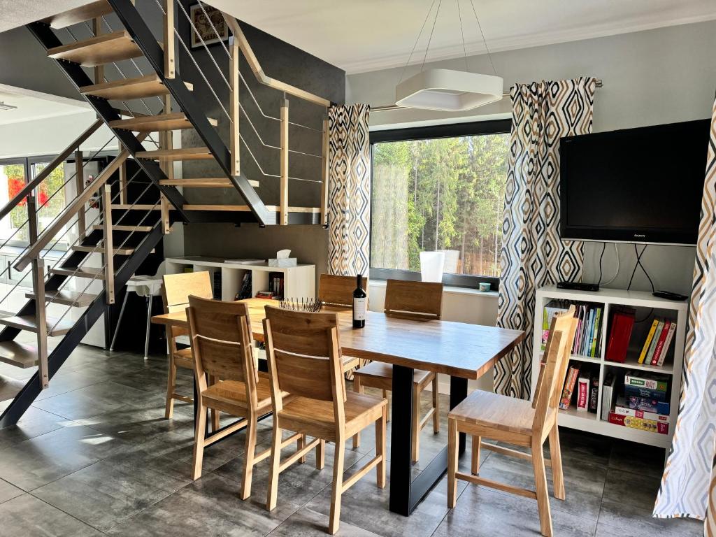 a dining room with a table and chairs and a staircase at Dom na Mlaskawce in Istebna