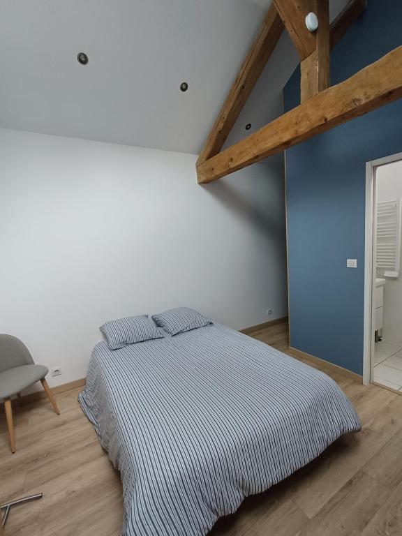 une chambre avec un lit et un mur bleu dans l'établissement Logement F1 neuf indépendant, à Belfort