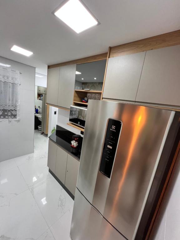 a kitchen with a stainless steel refrigerator at BARRAVENTO RESIDENCE - RIVIERA SÃO LOURENçO in Bertioga