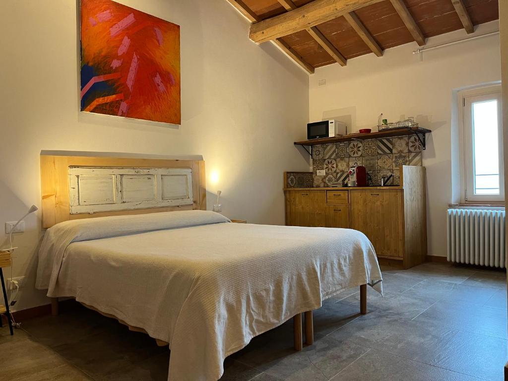 Un dormitorio con una cama y un cuadro en la pared. en Camera tripla Il Picchio Verde, en Altopascio