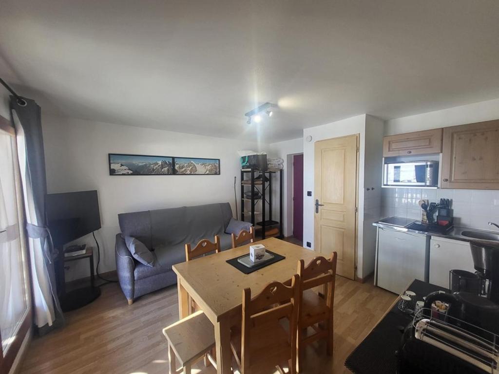 Il dispose d'une cuisine et d'un salon avec une table et un canapé. dans l'établissement Appartement cosy avec terrasse ensoleillée, au pied des pistes de Montgenèvre, tout équipé - FR-1-266-219, à Montgenèvre