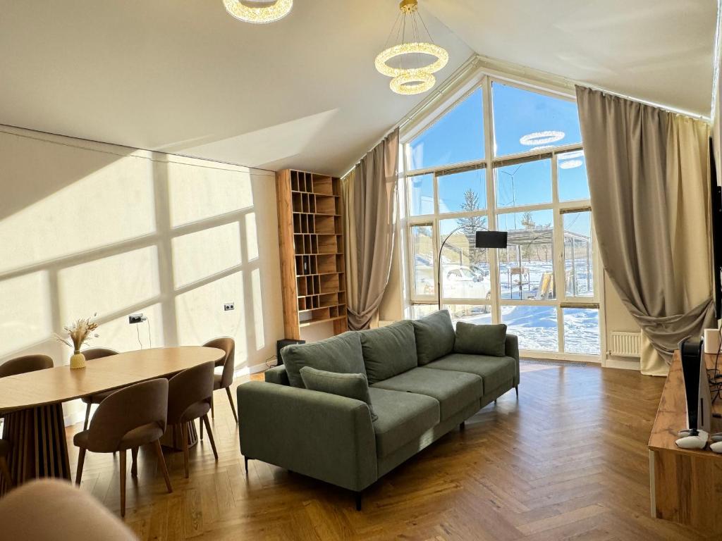 a living room with a couch and a table at Гостевой дом Burabay Grand Village in Borovoye