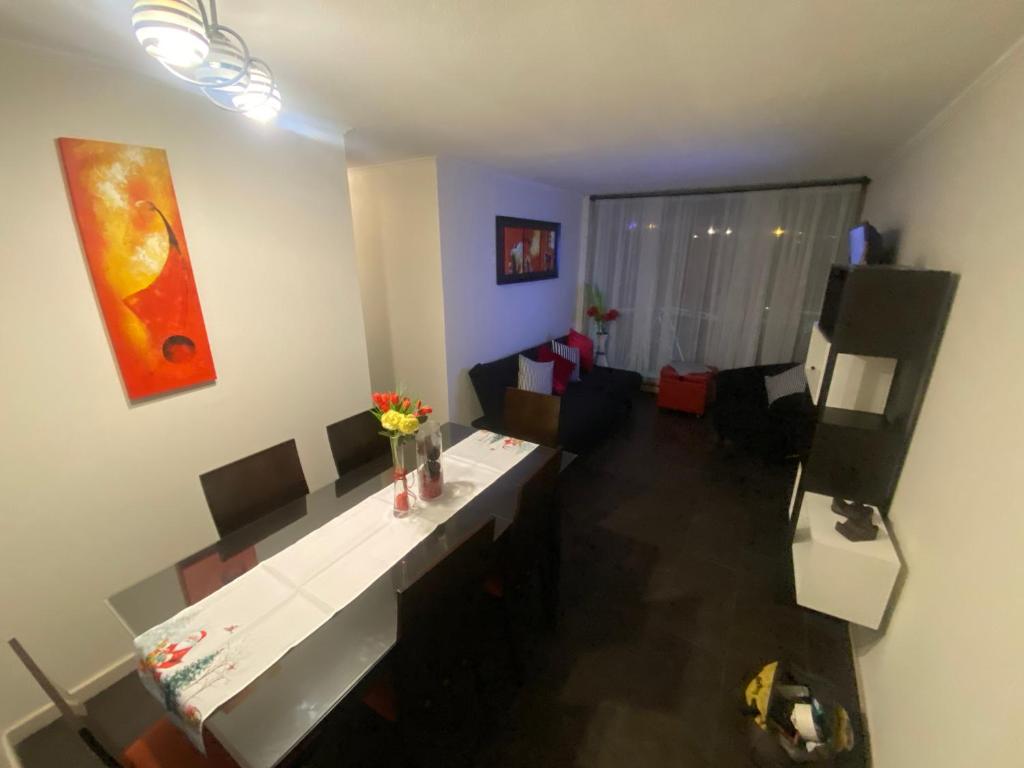 a living room with a white table and a couch at Departamento Peñuelas in La Serena