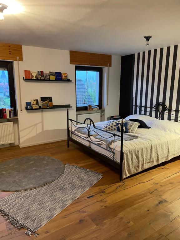 a bedroom with a bed and a large window at TinyStory - das Appartement mit Hotelgefühl in Obernburg in Obernburg am Main