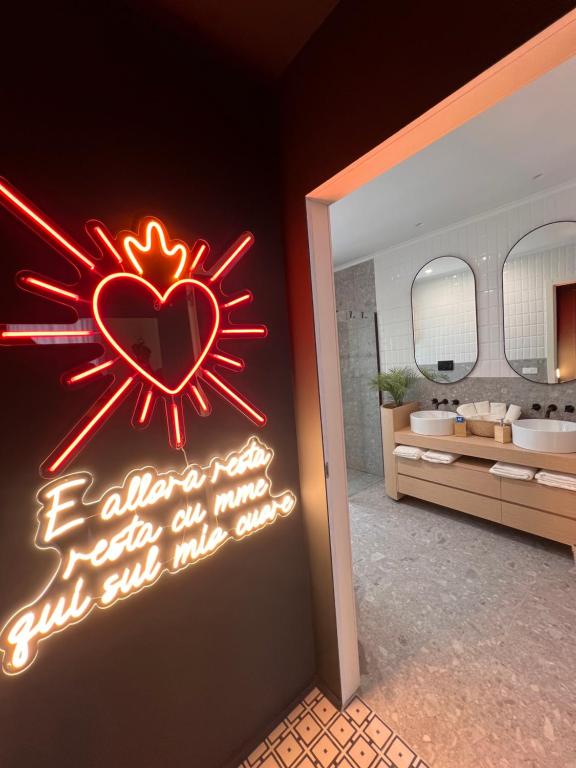 una señal de neón en una habitación con baño en Domus MARIA VITTORIA, en Nápoles