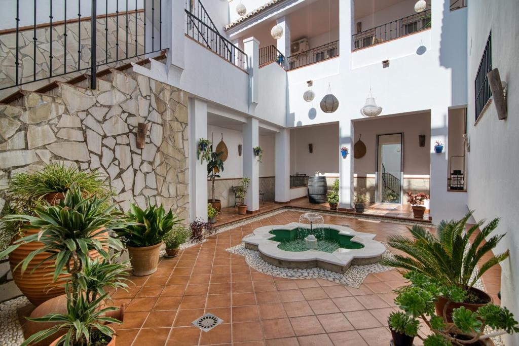 a courtyard with a fountain and plants in a building at La Perla de Frigiliana Suites & Villa in Frigiliana