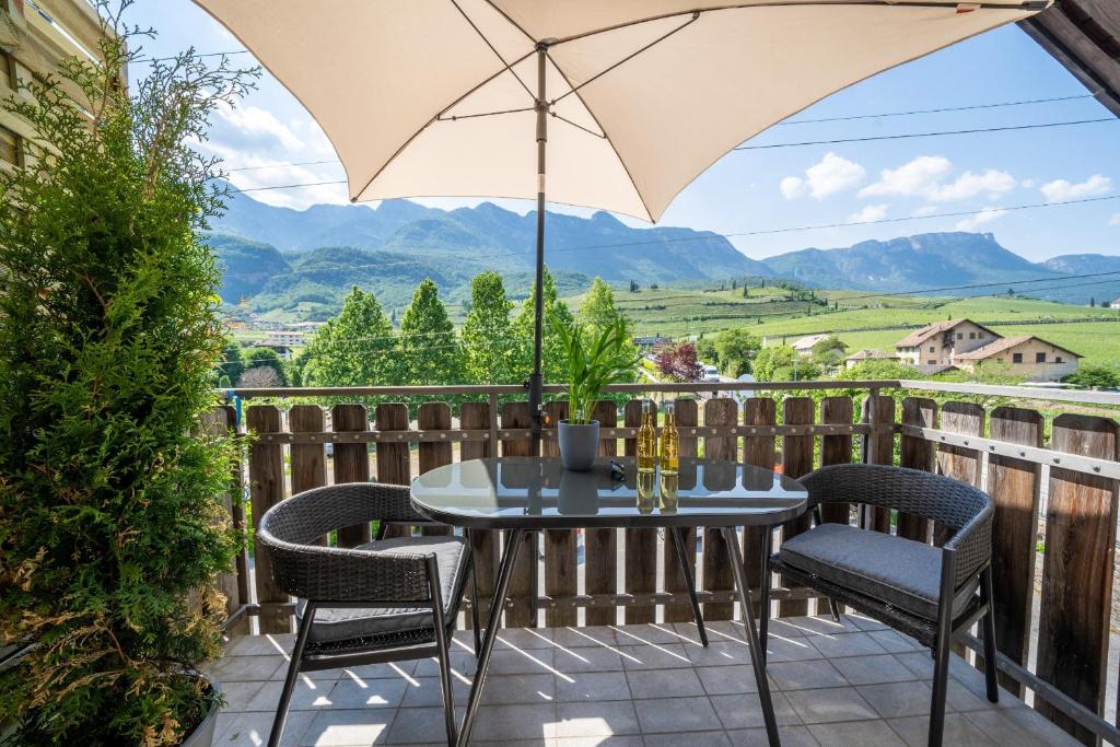 un patio con tavolo, sedie e ombrellone di Apartment Am See 3 a Castelvecchio