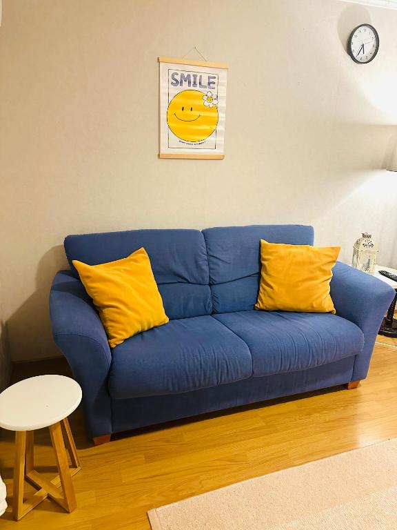 a blue couch with yellow pillows in a living room at Polku Apartaments in Imatra